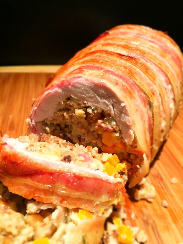 bacon wrapped stuffed pork loin on cutting board
