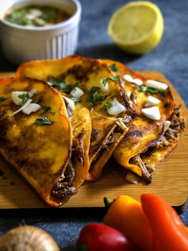 tortilla stuffed with beef and cheese on a board on top of table