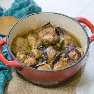 poultry braised in a pot with sauce on top of table