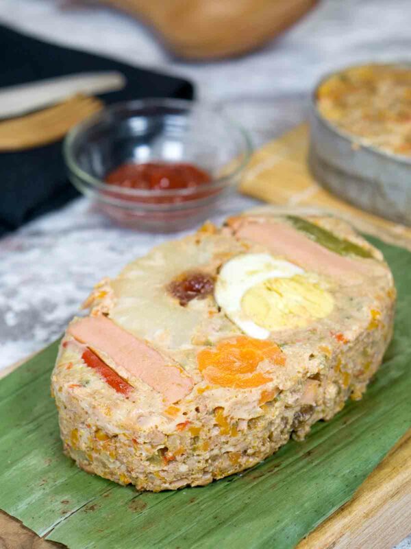 meatloaf on top of board lined with banana leaf