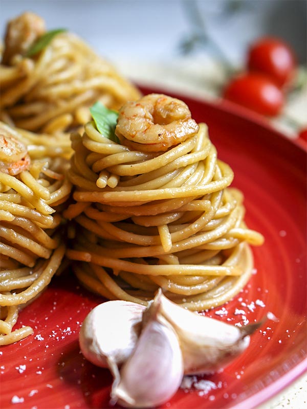 pasta with shrimps in a plate on top of table