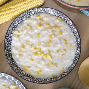 pudding with cream and corn in a bowl on top of table