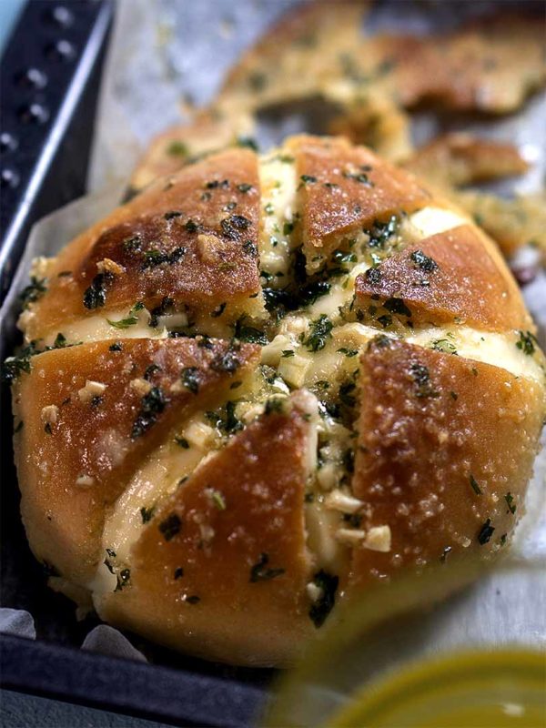 buns with garlic sauce coating in a pan