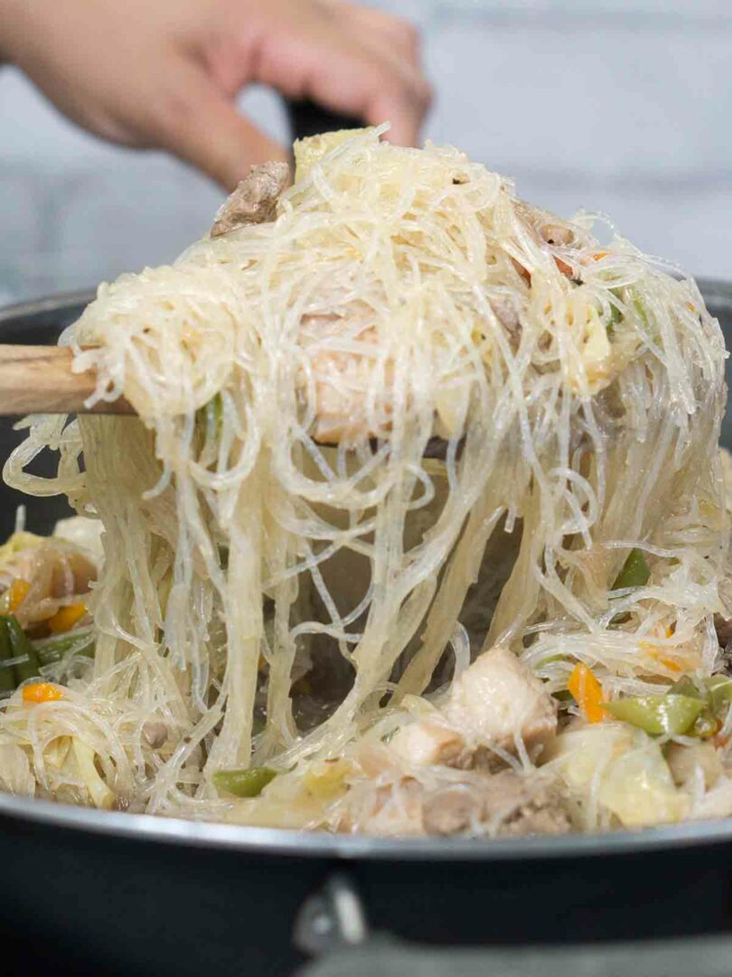 vermicelli being added to a wok