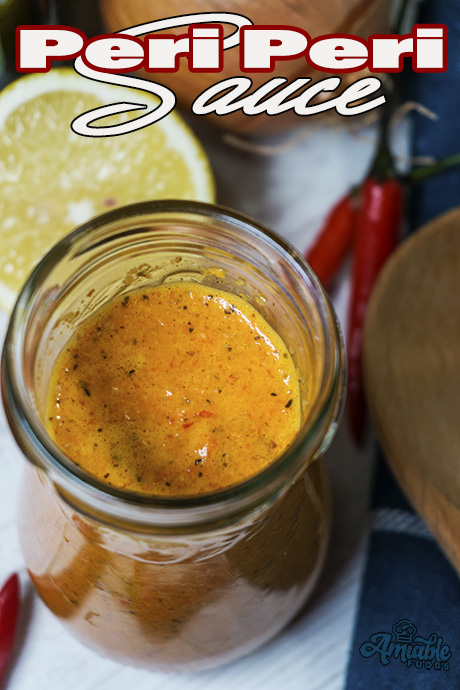 hot sauce in a jar with chili and slice of lemon besides it