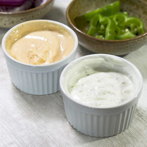 white and spicy condiments in bowls on top of table