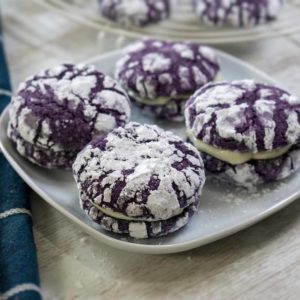 cookies with cream filling coated in sugar in a plate on top of table